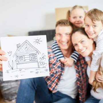 Junge Familie mit Zeichnung von neuem Eigenheim
